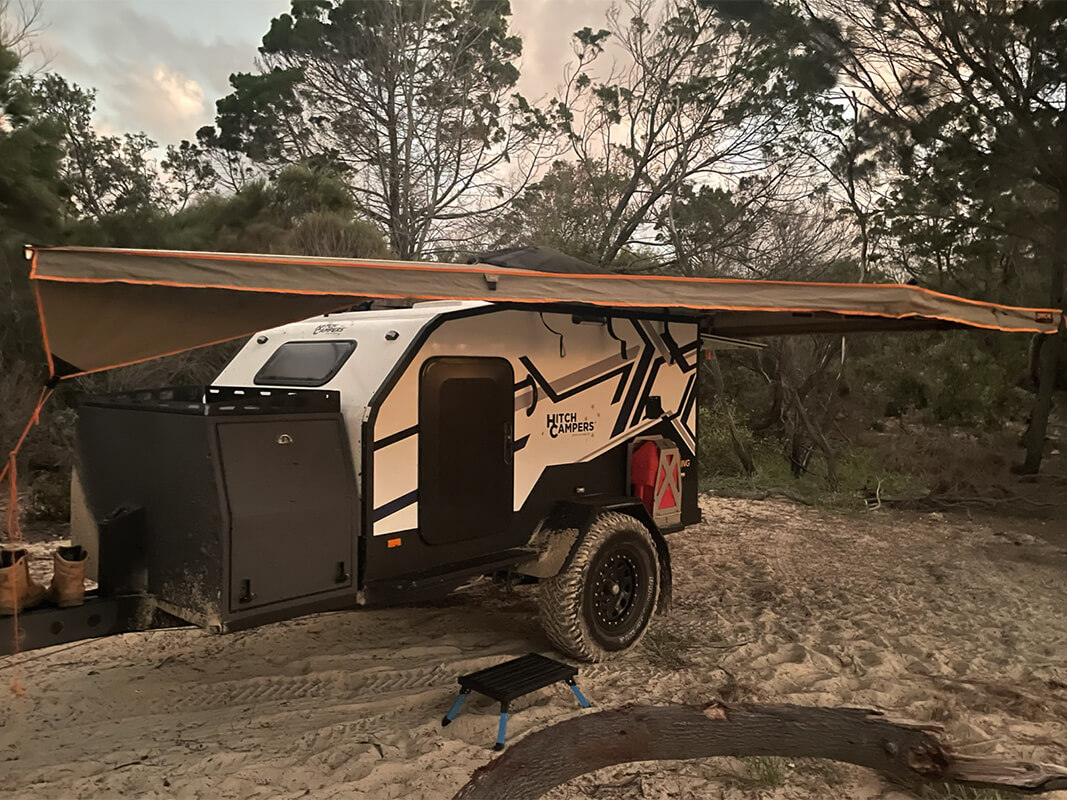 Hitch teardrop camper set up on sand